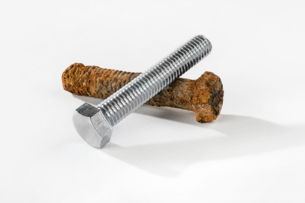 Two threaded screws, one rusted and corroded and one protected with corrosion preventive fastener coating